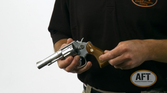 An AFT instructor demonstrating safe gun handling of a revolver.